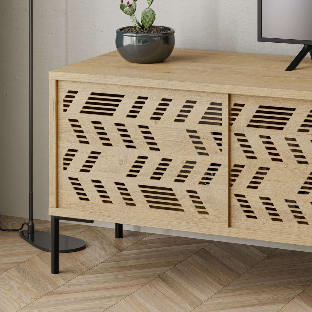 Close-up of patterned cabinet door on light oak TV stand