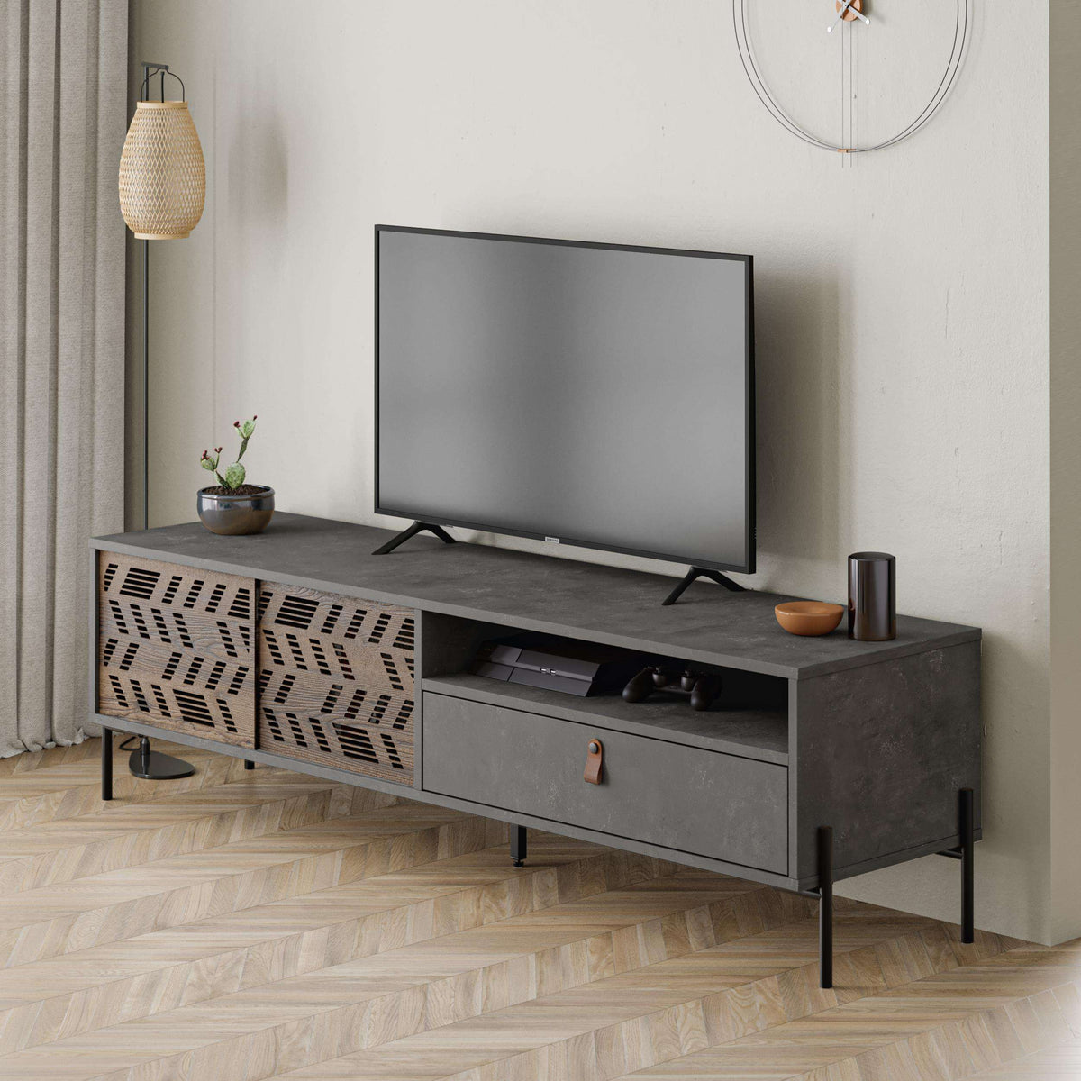 Modern TV stand in dark grey with perforated doors, open shelf, and central drawer