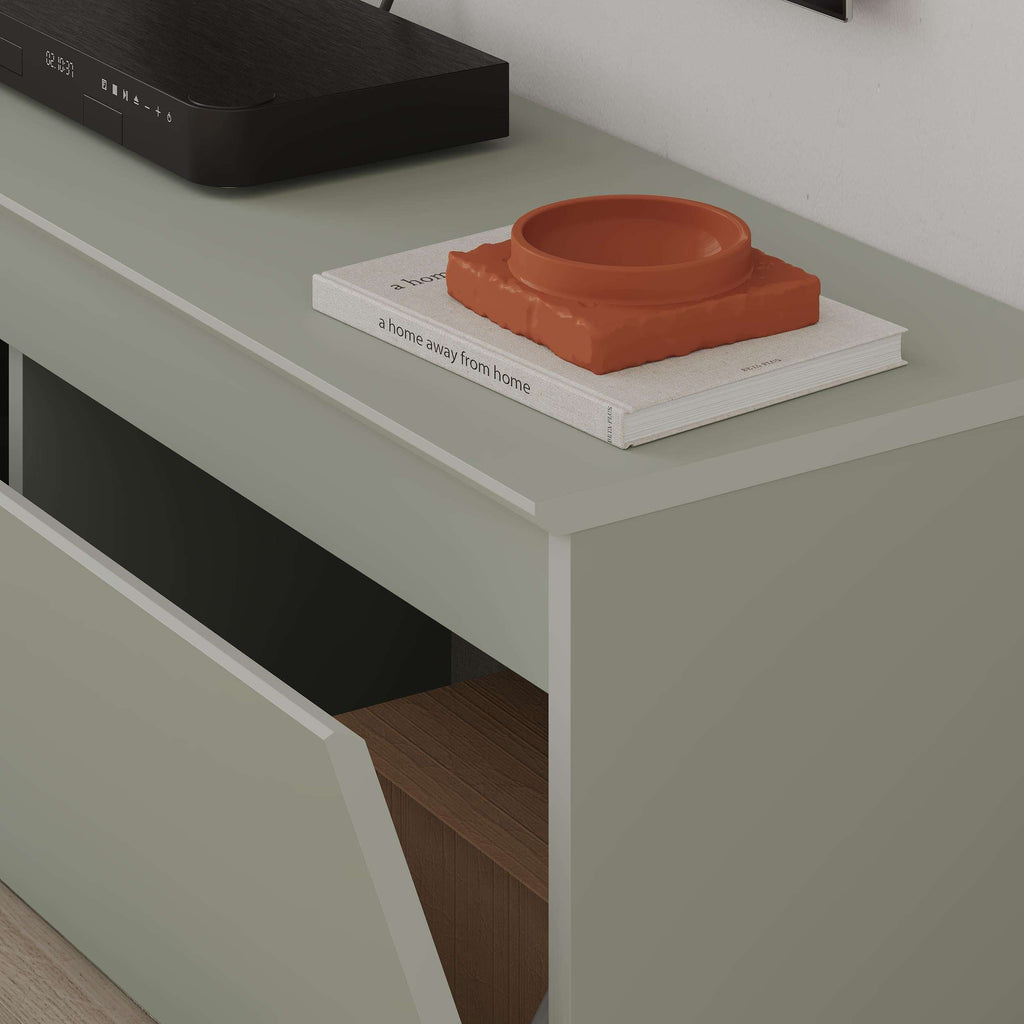 White TV low board with open storage compartment and orange bowl on top