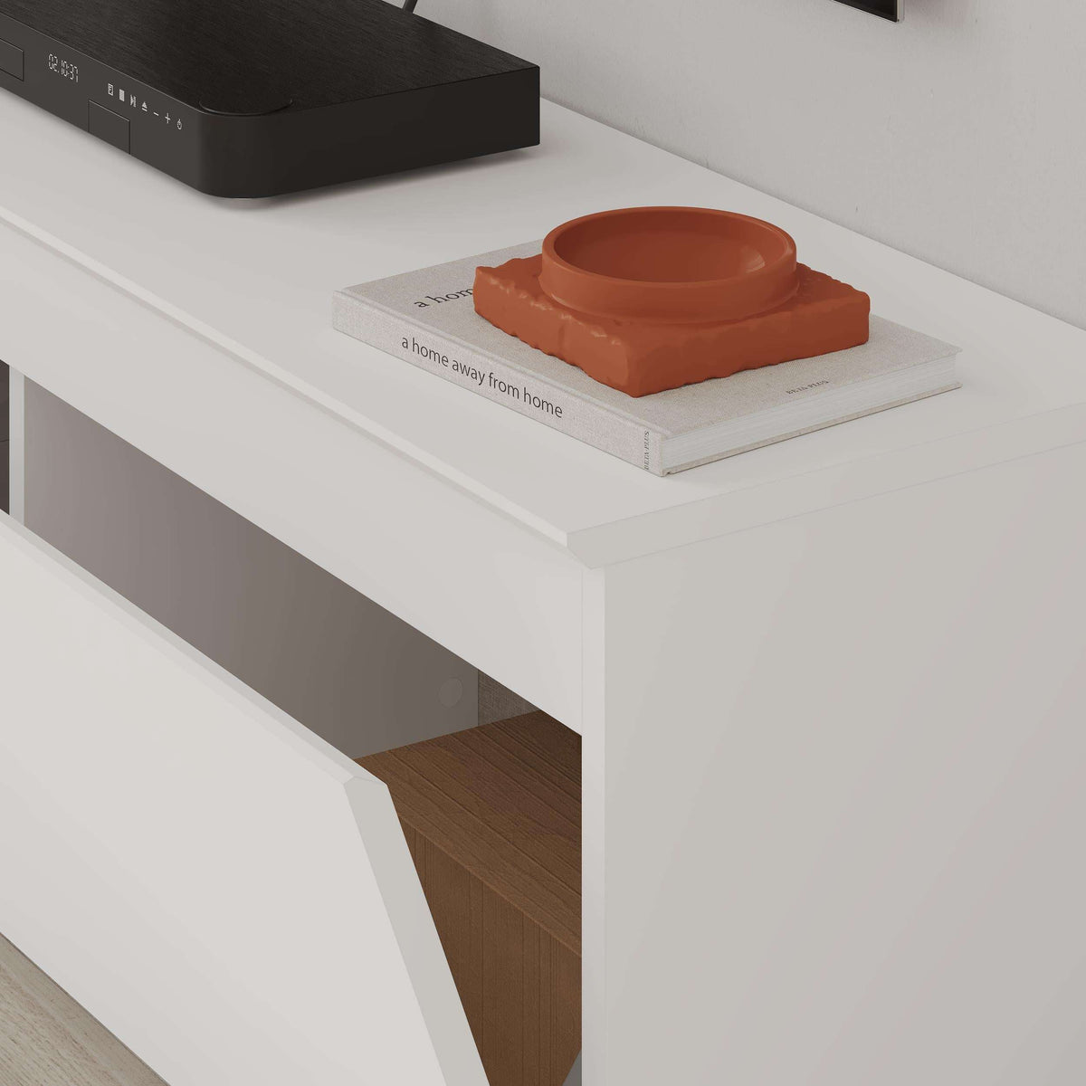 White TV low board with open storage compartment and orange decor on shelf