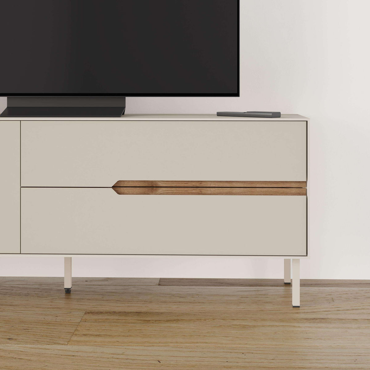 Modern TV unit drawer front with wood bar handle on light sand cabinet, two-tone legs.