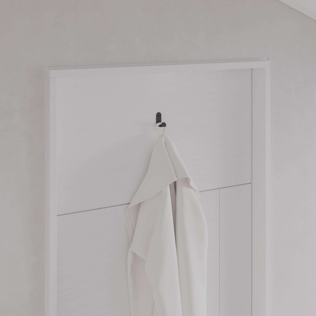 Black metal wall hanger hook set of 3 holding folded white towels on a door