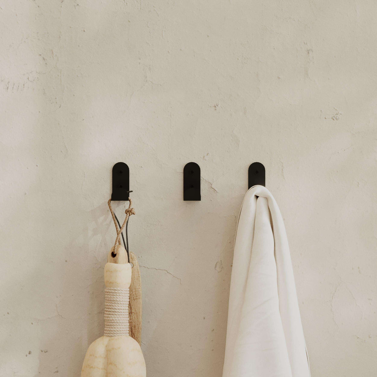Set of 3 black metal wall hooks with screw holes for hanging coats