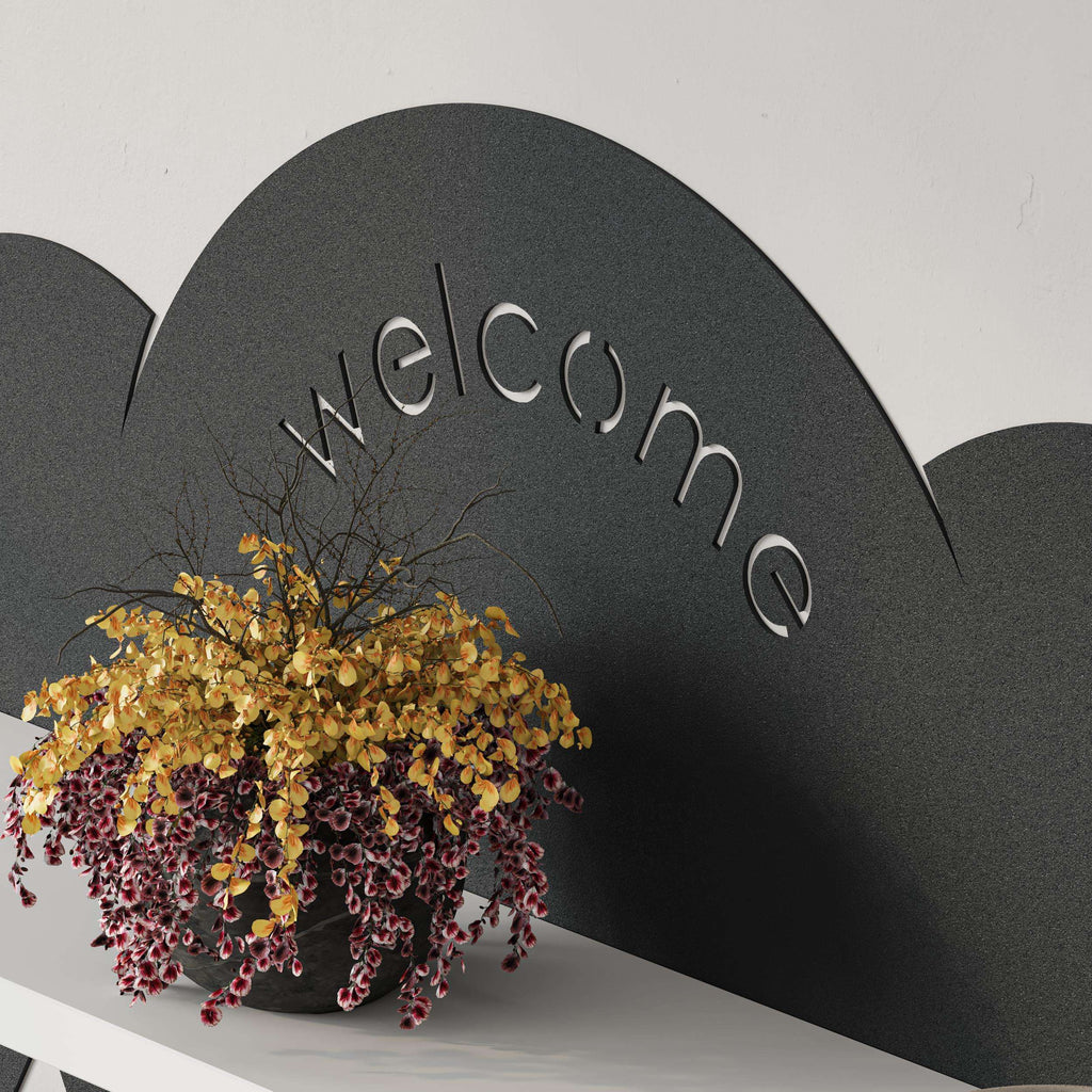 Close-up of cloud top with raised “welcome” lettering on wall hanger shelf