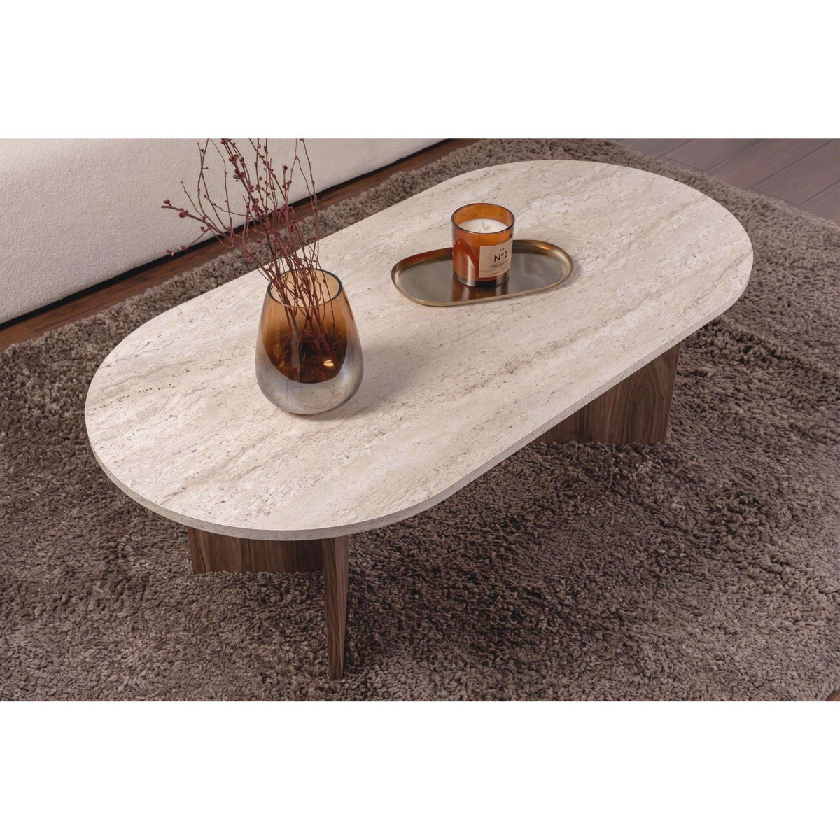 Oval coffee table with light stone top and dark wood pedestal legs