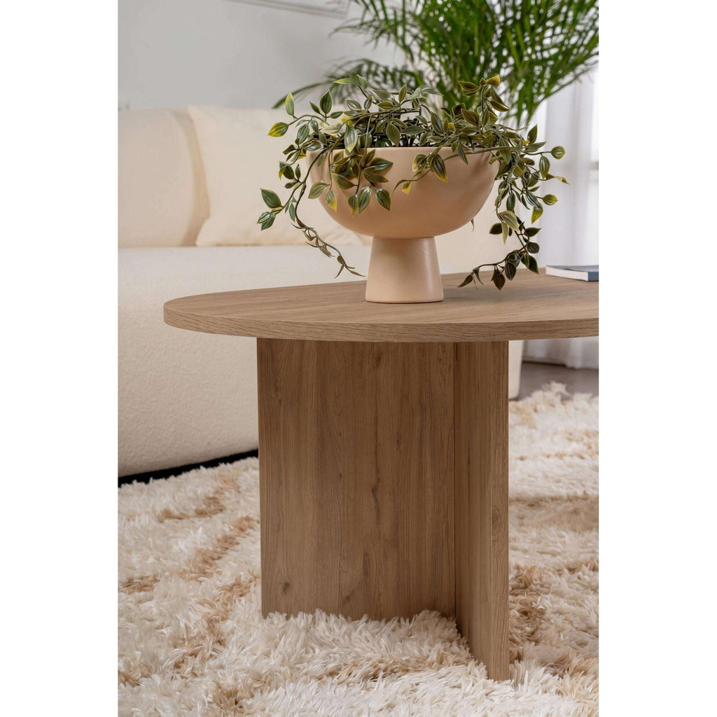 Oak oval coffee table with round top and pedestal-style side panel.