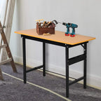 Foldable work bench with orange MDF top and black steel frame, tools on tabletop