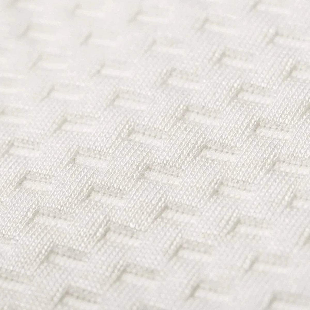 Close-up of white textured bamboo fabric weave on the mattress surface.
