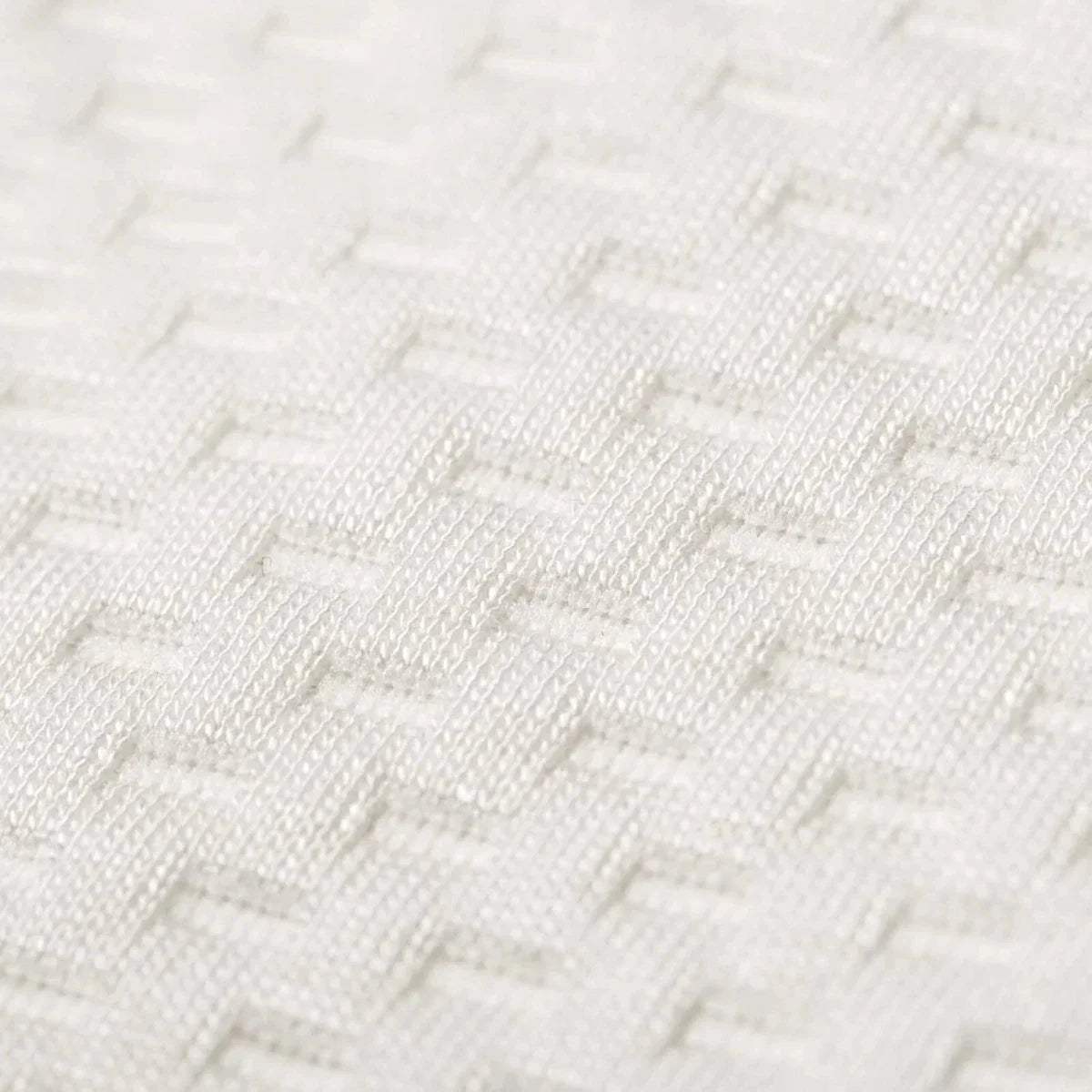 Close-up of white textured bamboo fabric weave on the mattress surface.