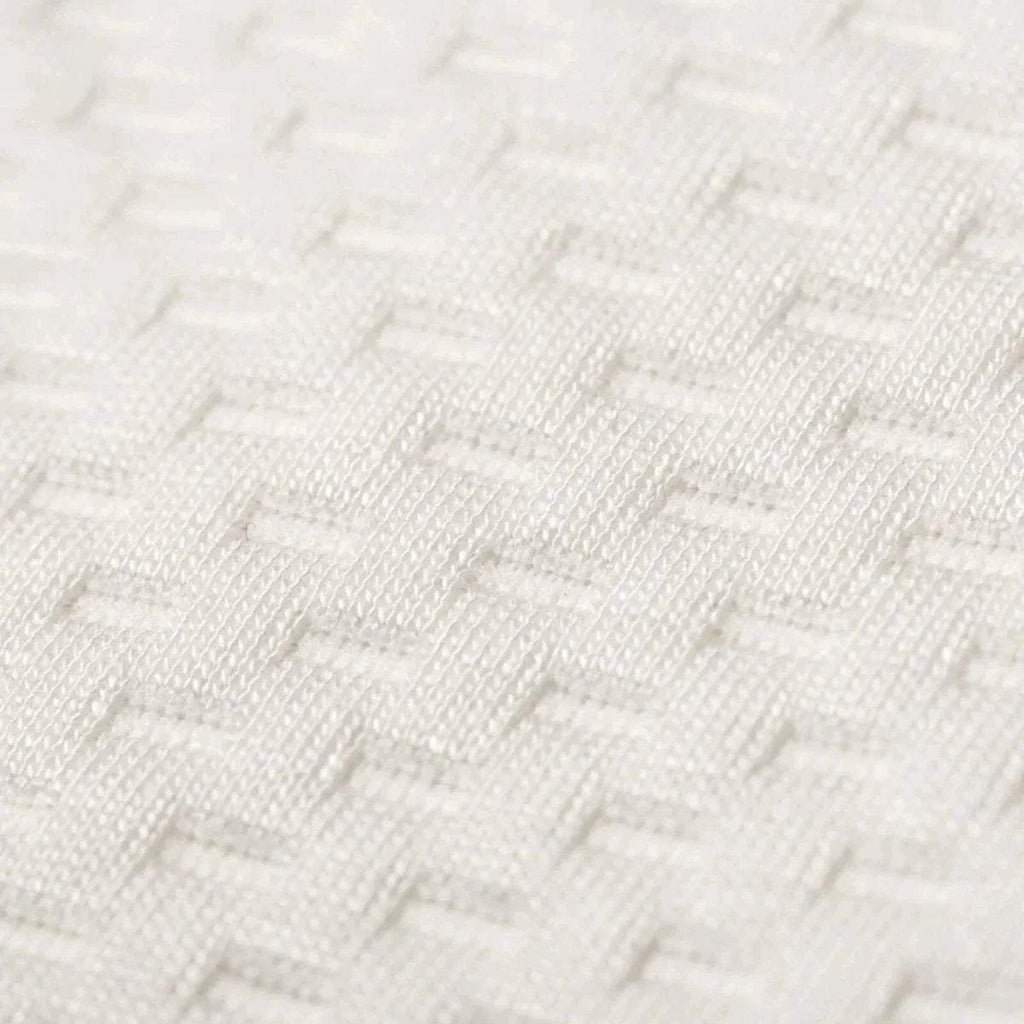 White knitted mattress cover fabric texture, close-up.