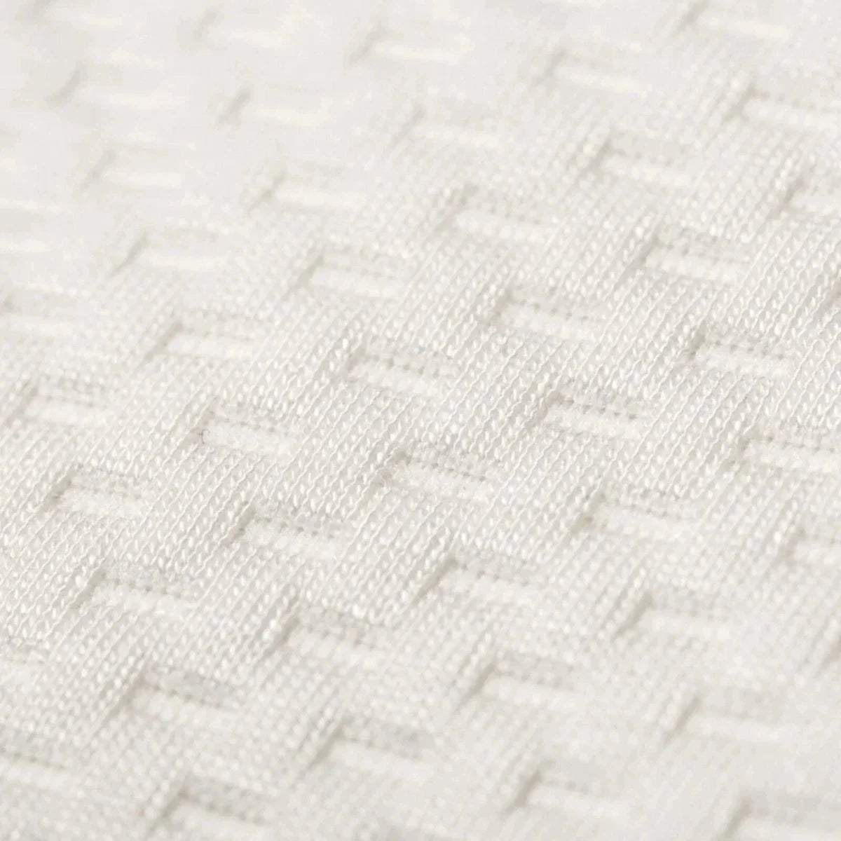 White knitted mattress cover fabric texture, close-up.
