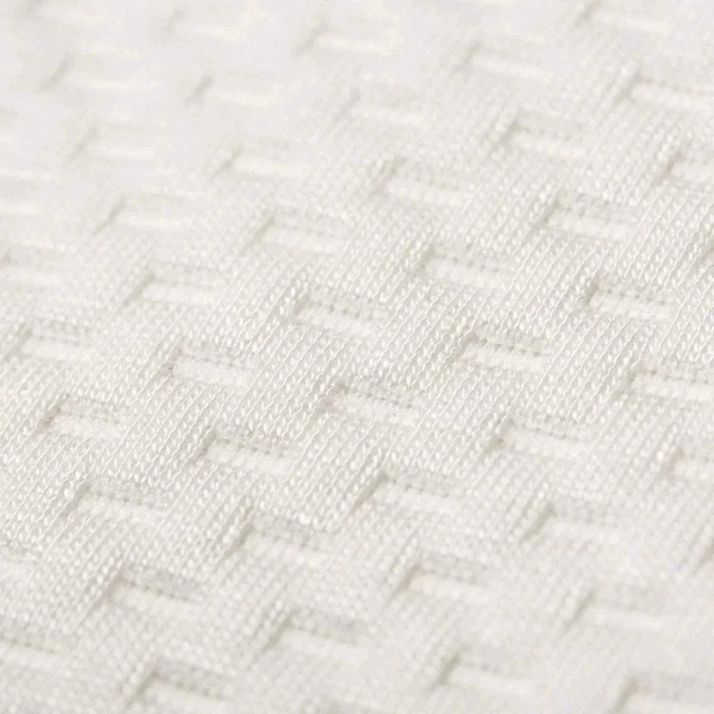 White knitted mattress cover close-up with textured weave pattern