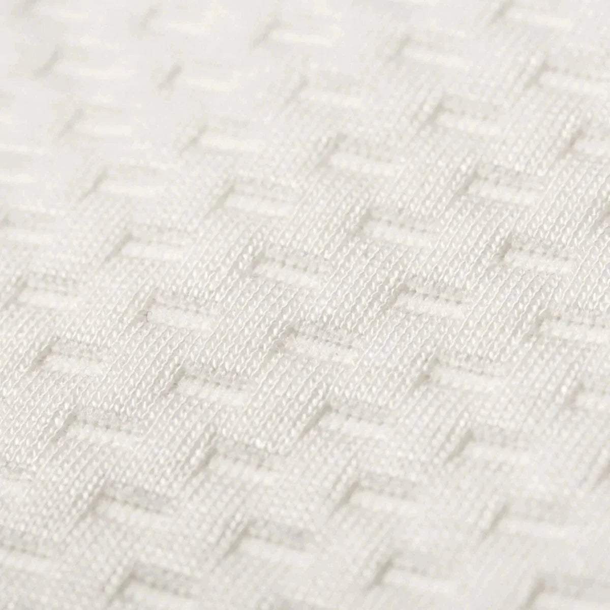 White knitted mattress cover close-up with textured weave pattern