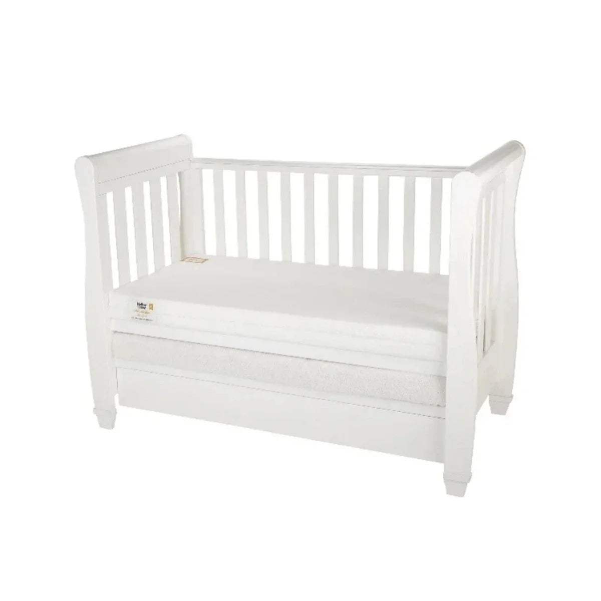 White cot bed mattress with quilted surface on a white wooden crib frame