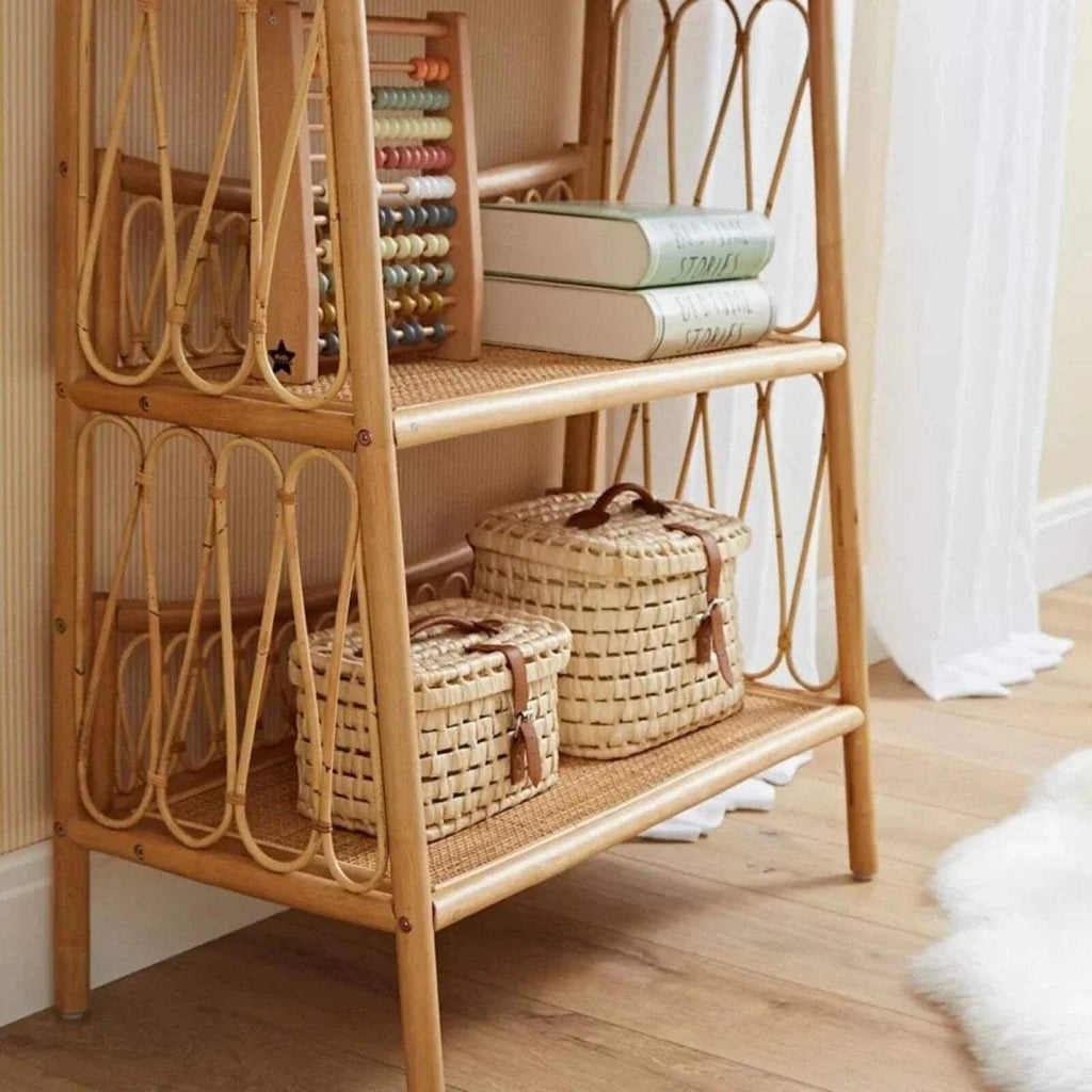 3-tier rattan shelving unit filled with woven baskets and folded books