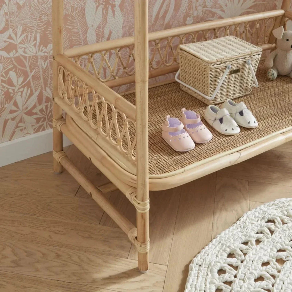 Light natural rattan clothes rail corner view with hanging rail, front lattice panel, and shelf.