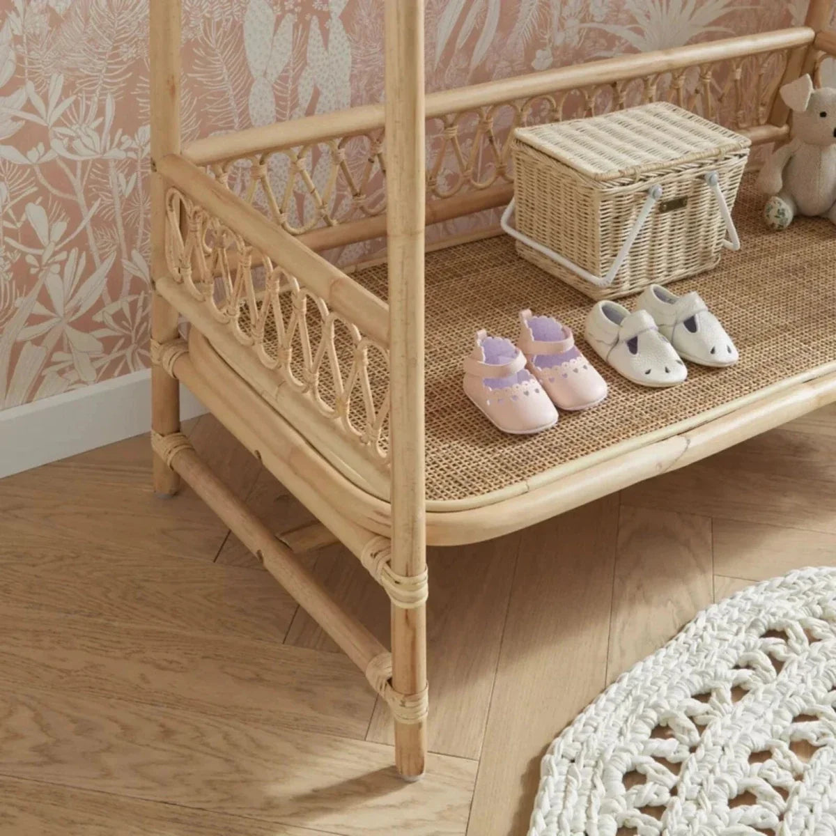 Light natural rattan clothes rail corner view with hanging rail, front lattice panel, and shelf.