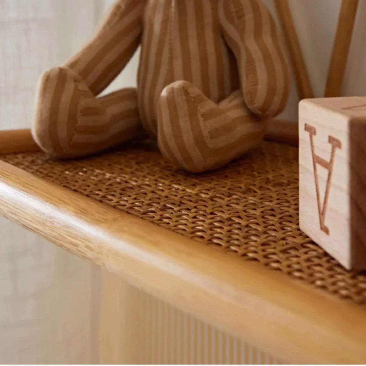 Woven rattan shelf surface with rounded front edge and curved end supports