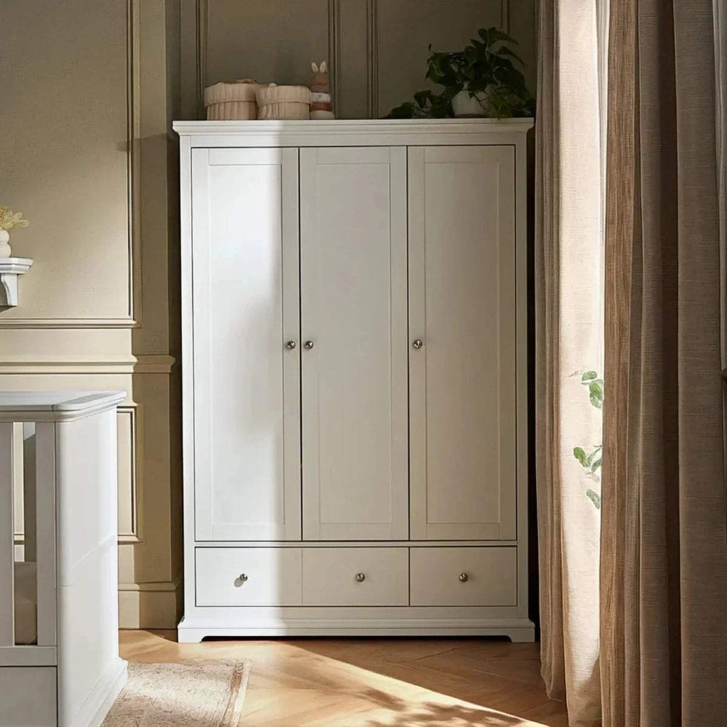 White triple-door wardrobe cabinet with two lower drawers and open shelf area
