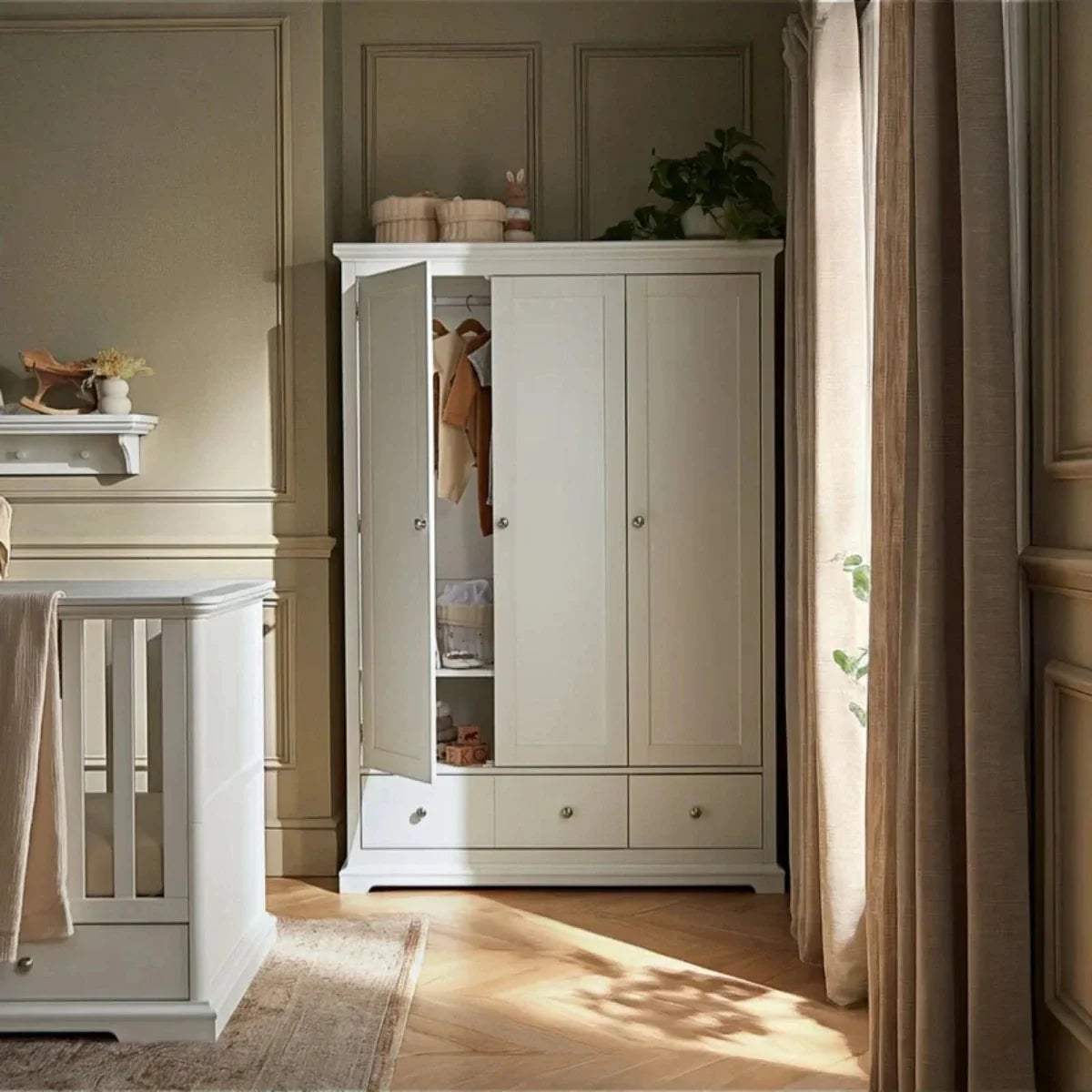 White triple-door wardrobe with one door open, revealing interior shelves and hanging rails