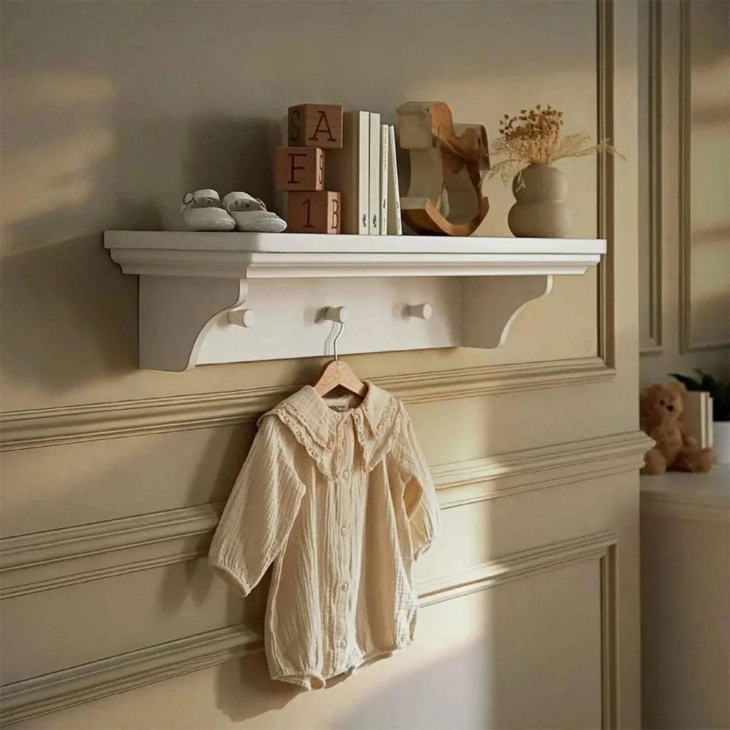 White wall shelf with scalloped apron edge and underside peg details
