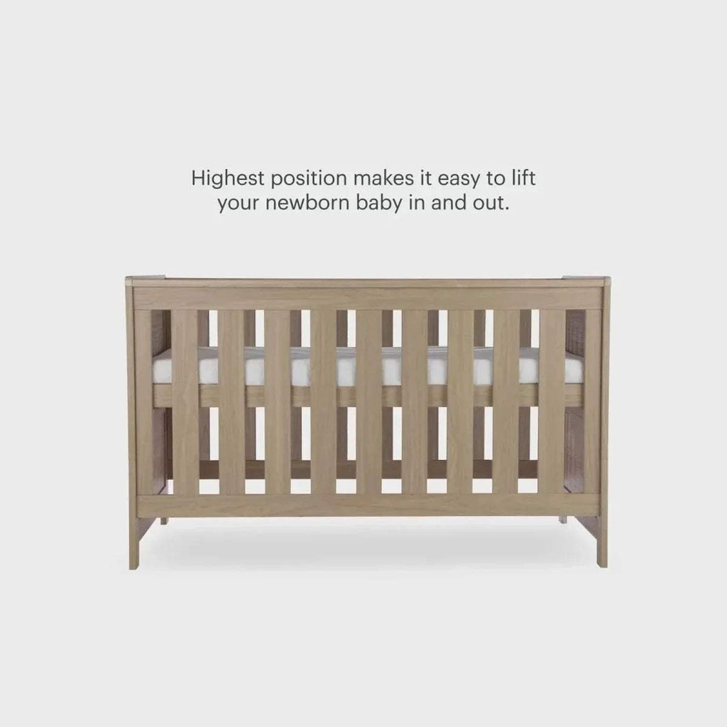 Oak cot bed front with vertical safety slats and raised end rails
