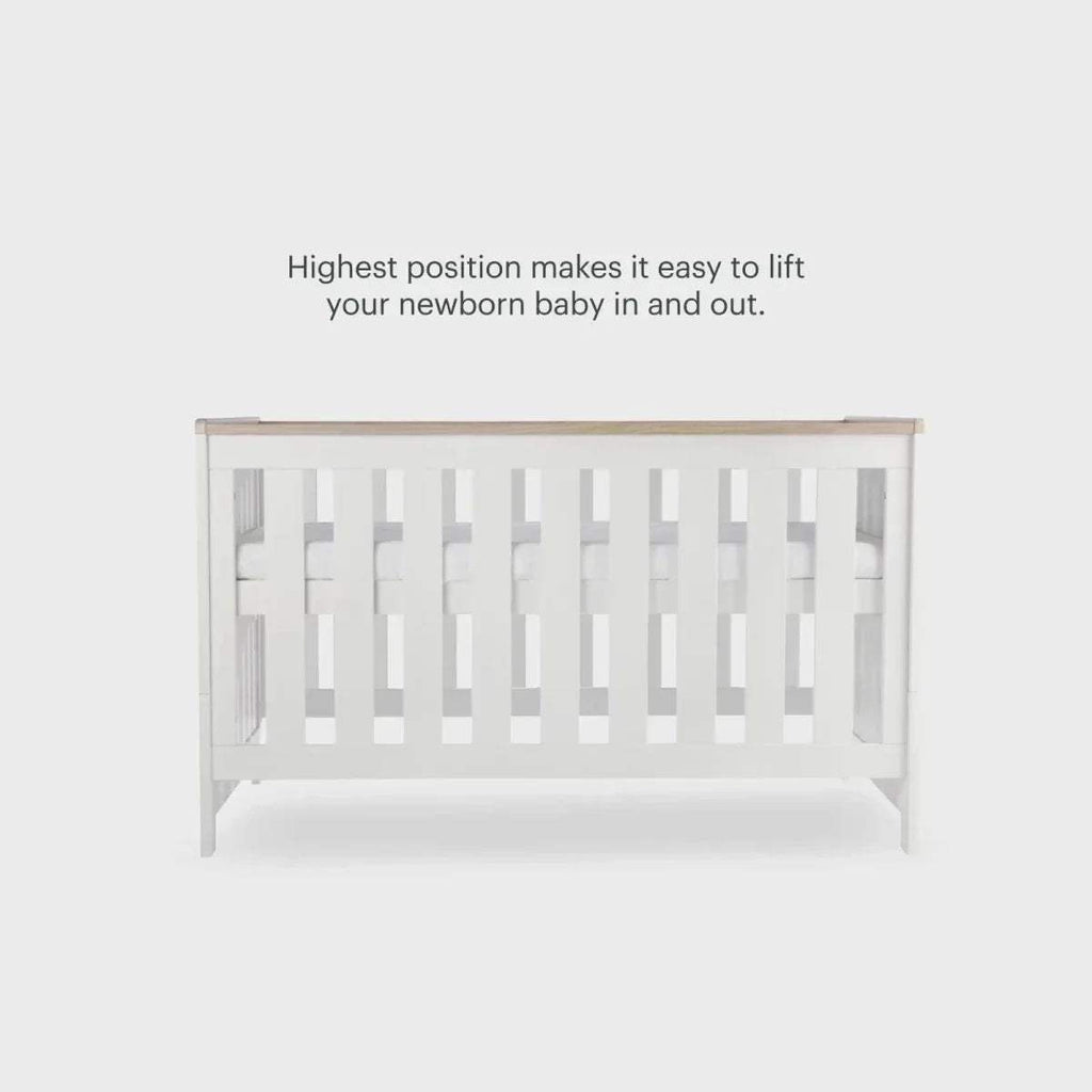 White cot bed end panel with vertical slats and oak-toned top rail