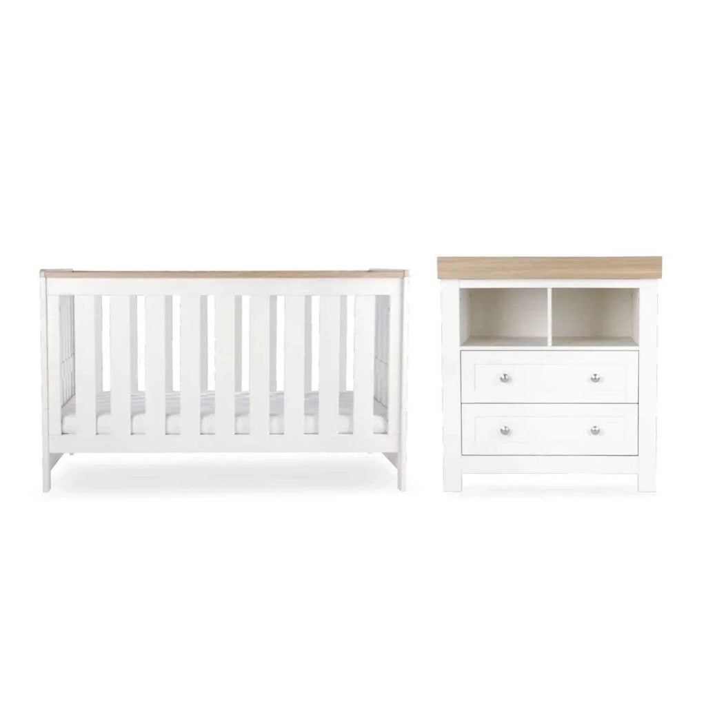 White nursery cot and matching dresser with drawer fronts and open shelves
