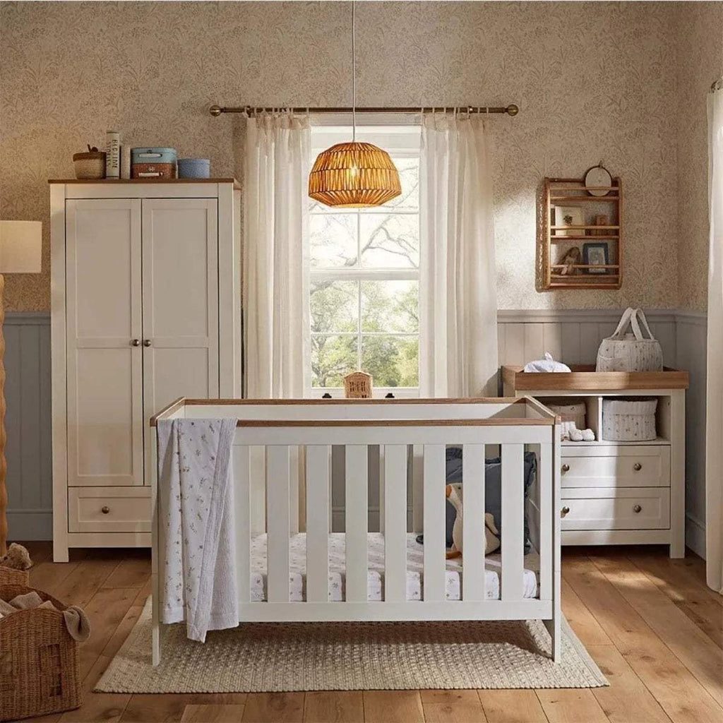 White nursery furniture set with crib, wardrobe, and changing dresser, oak accents