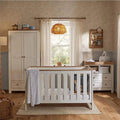 White nursery furniture set with crib, wardrobe, and changing dresser, oak accents