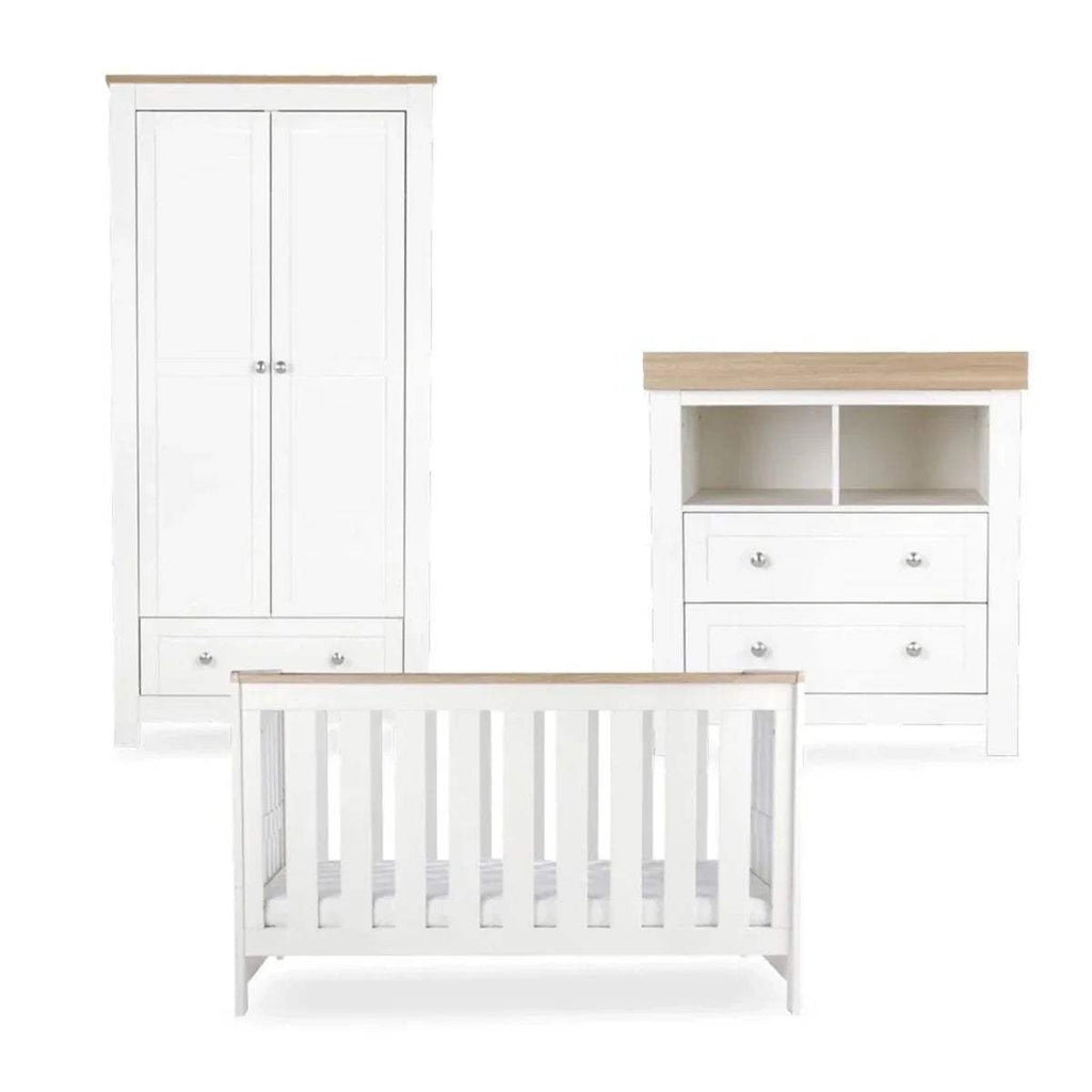 White crib with slatted sides, shown with matching wardrobe and storage dresser
