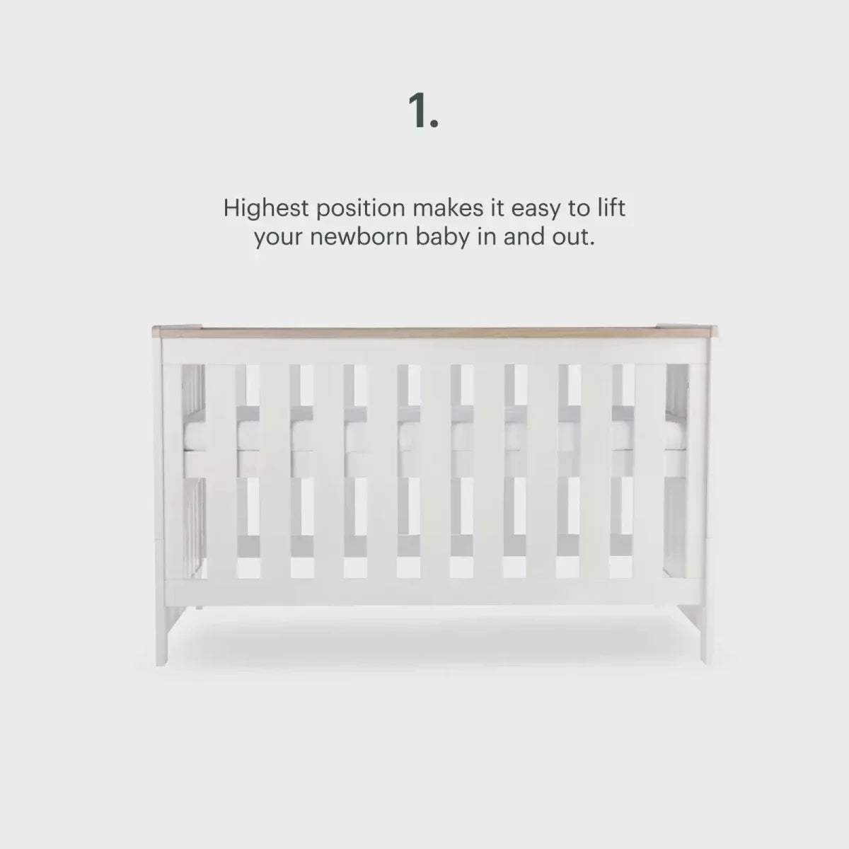 White cot with slatted sides at highest position, side view with height note