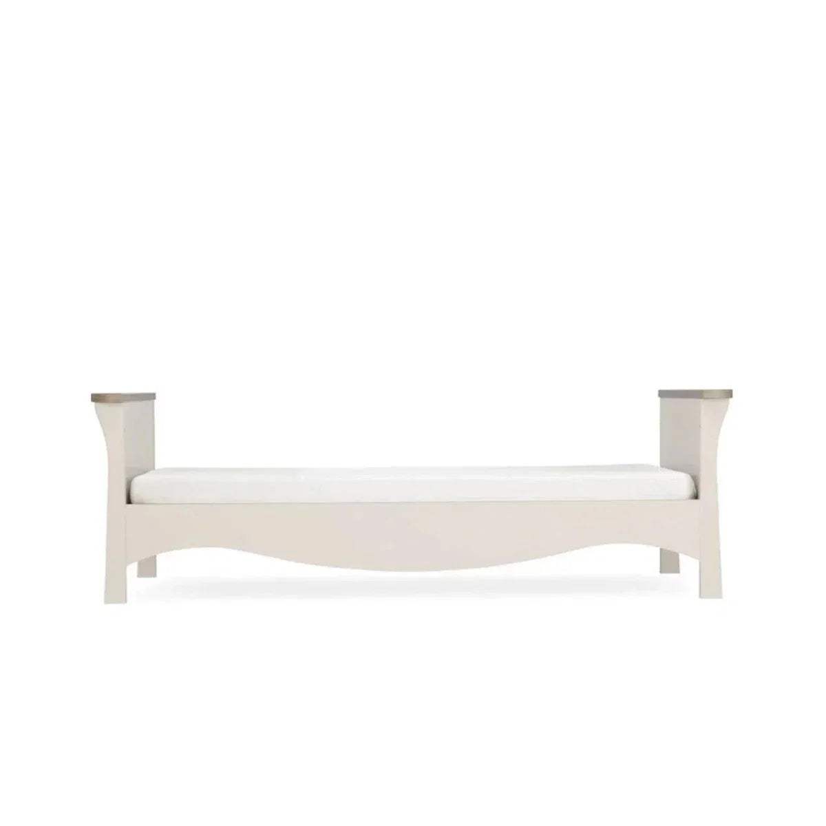 White toddler bed frame with curved rails and short legs, side view