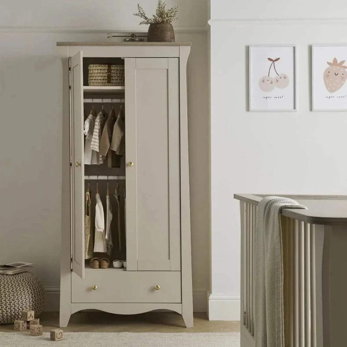 Off-white nursery wardrobe cabinet with open doors and interior shelves, in a nursery