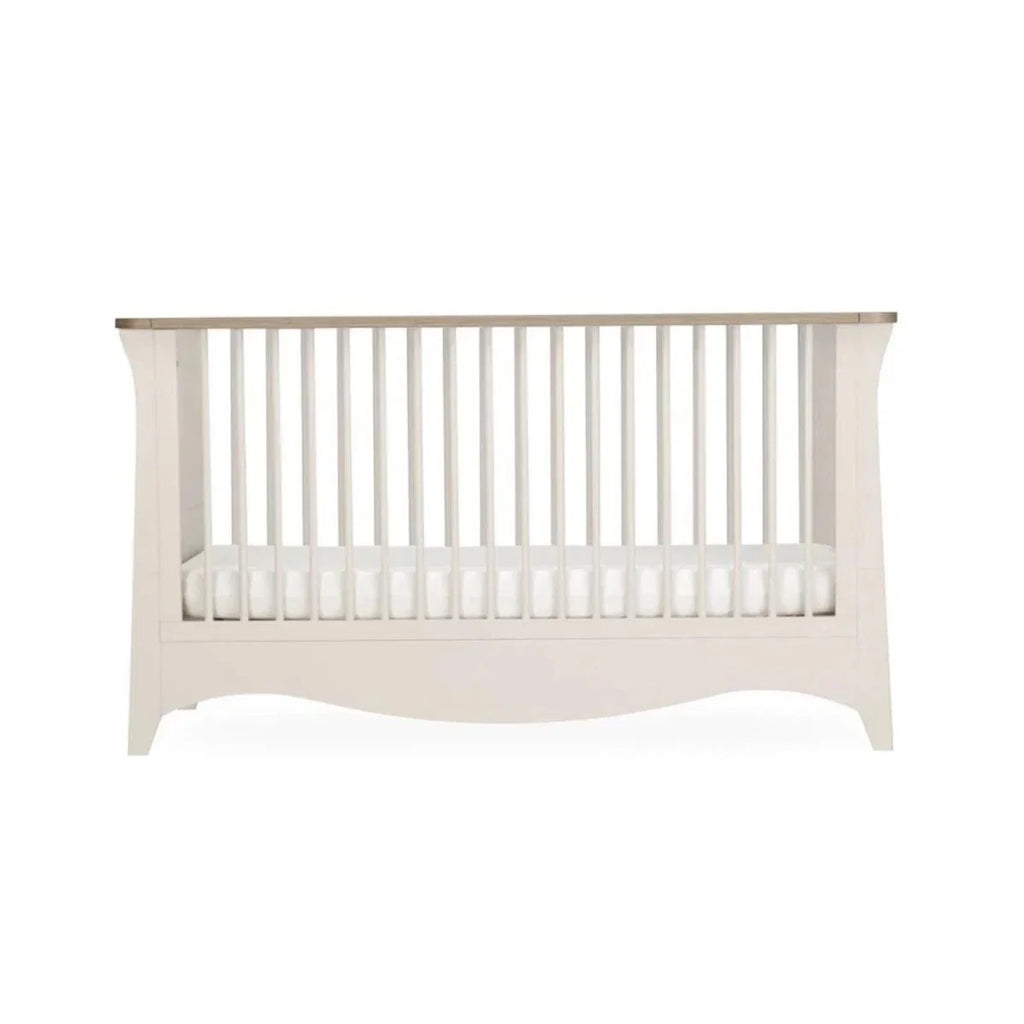White nursery crib with vertical slat guard rails, front view