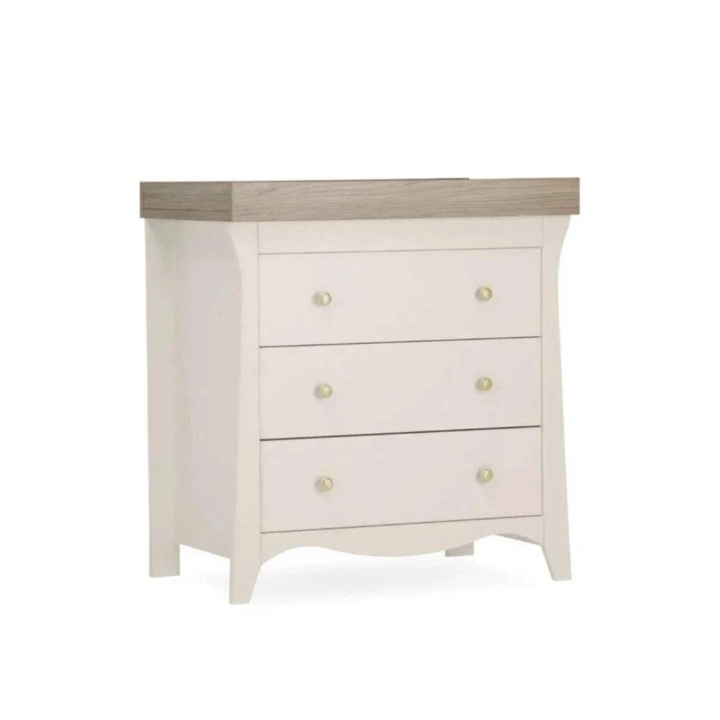 White dresser changer with wavy skirt base, three drawers, and gold knob handles