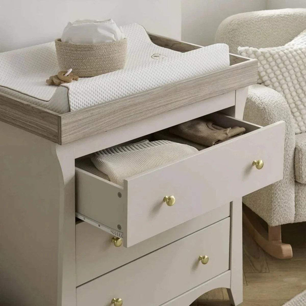 White dresser changer with open top drawer and inner compartments, gold knobs