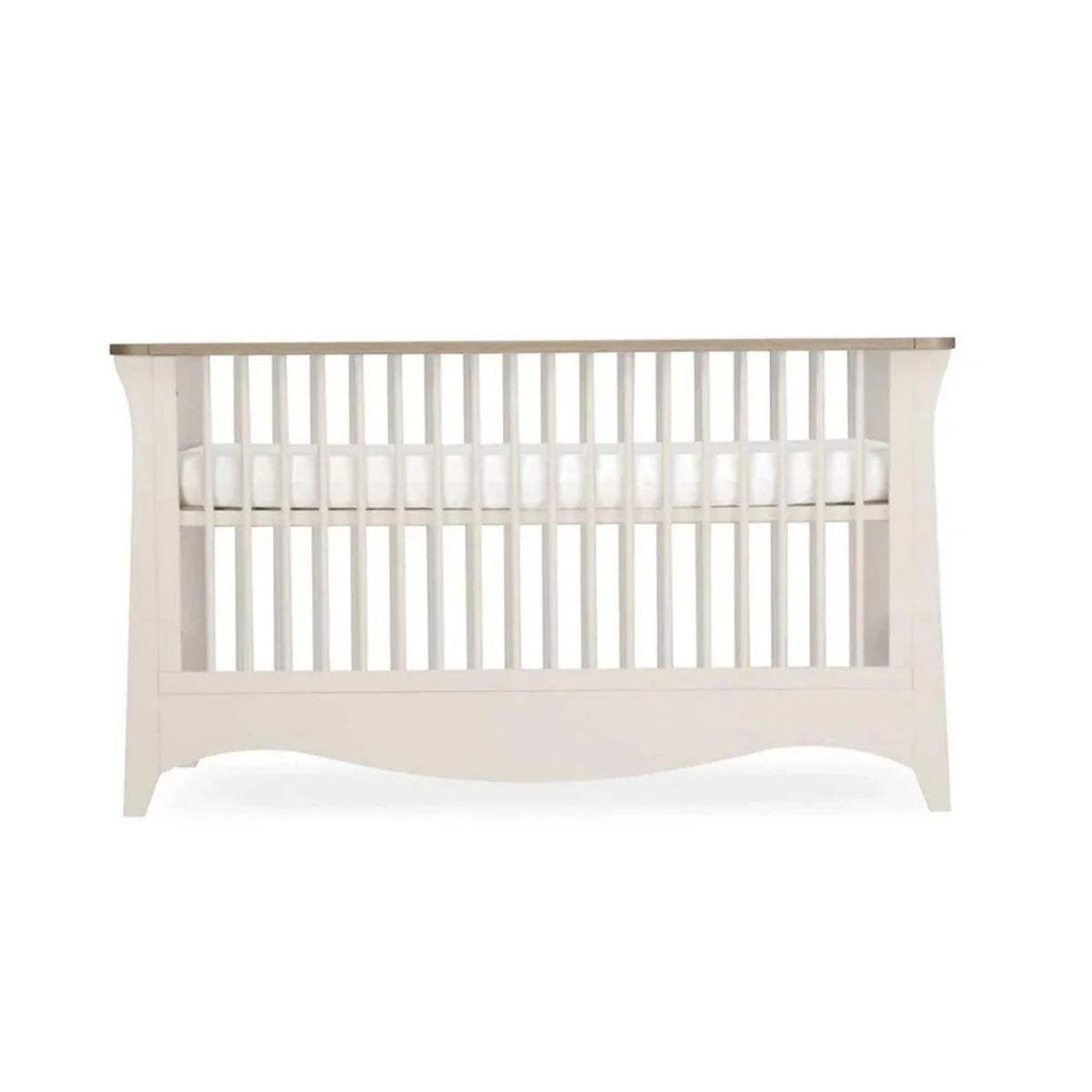 White cot bed with vertical slat headboard and open side rails