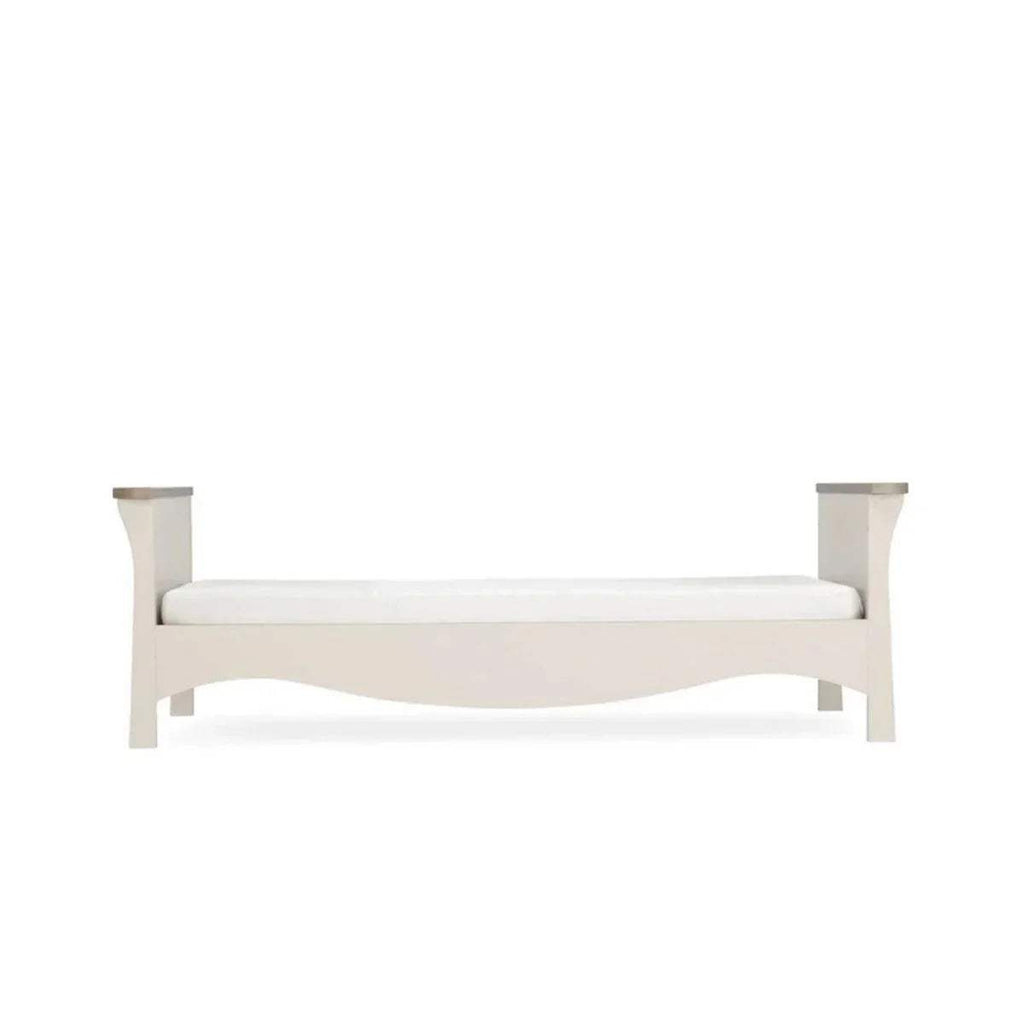 White cot bed frame with curved silhouette and low side rails