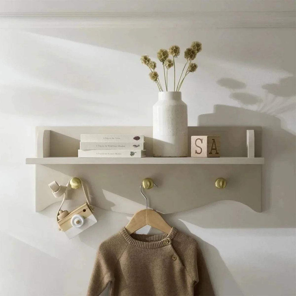 Nursery wall shelf in ash white with scalloped ledge and three brass knob pegs
