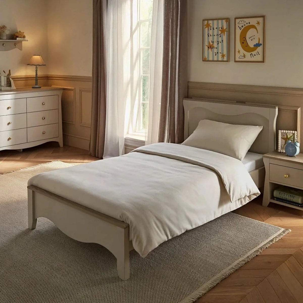 Cashmere-ash single bed with white pillows and upholstered headboard