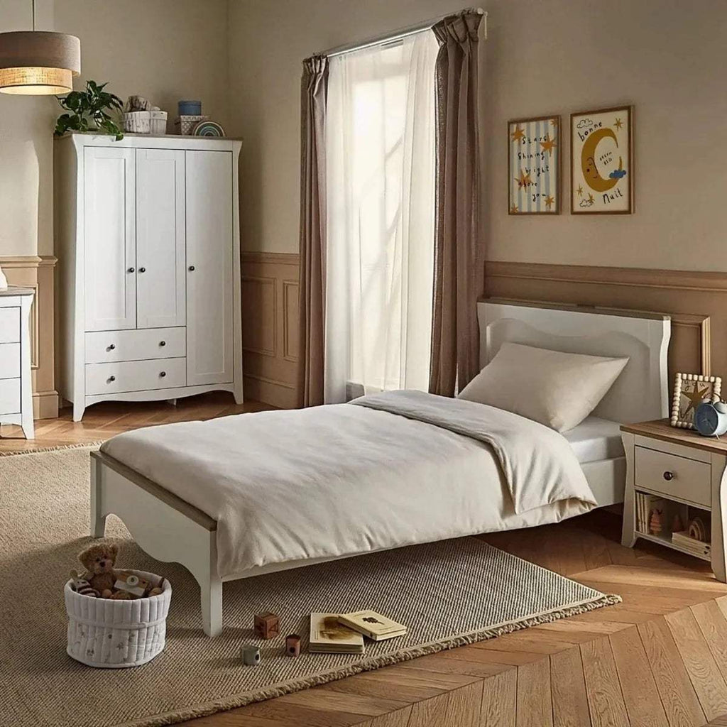 White single bed with curved headboard and footboard, light grey pillow