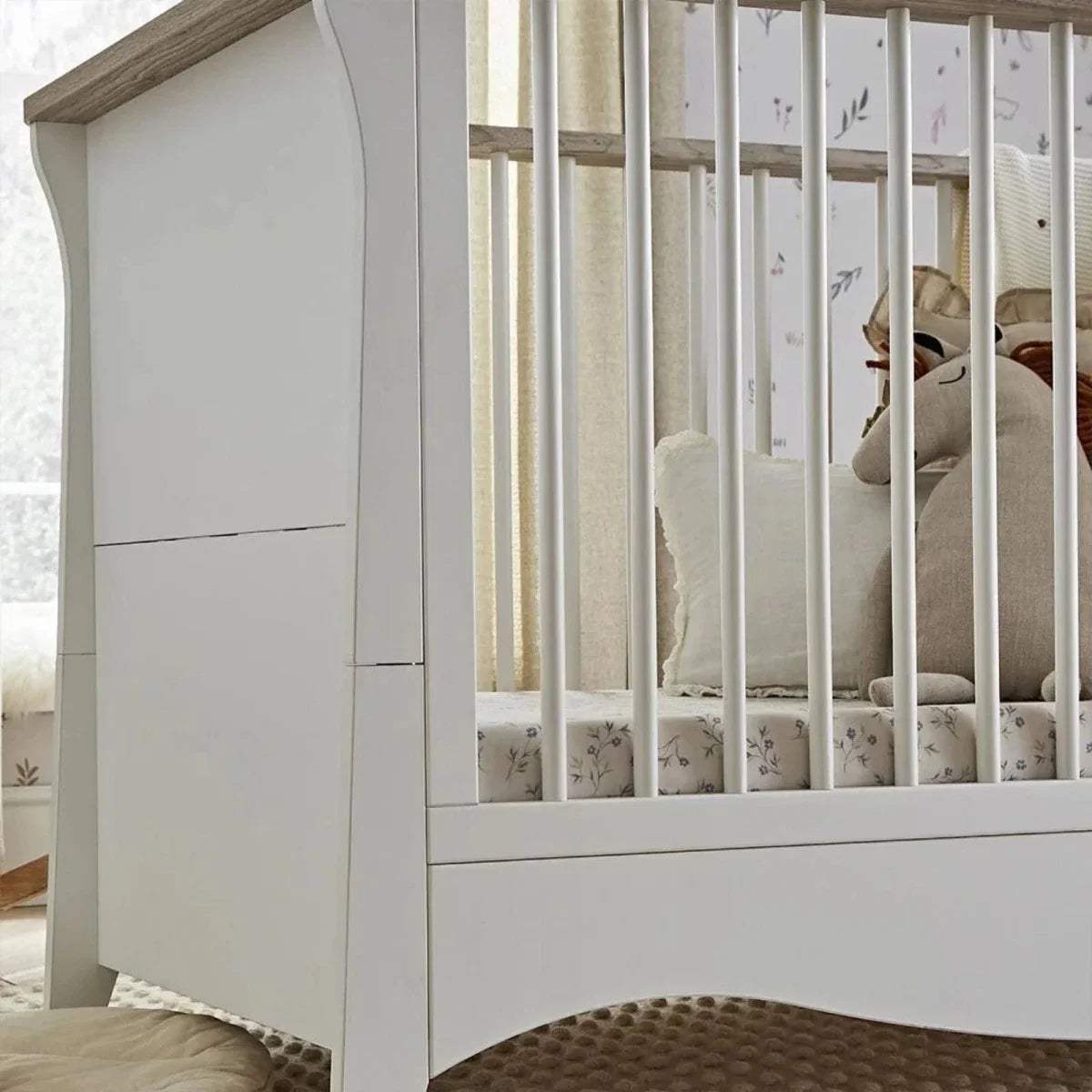 White nursery crib side panel with slat guard and light ash-toned top rail