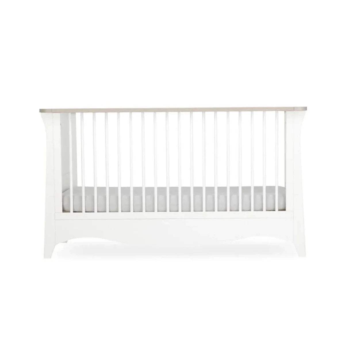 White nursery crib with vertical slats and solid lower panel
