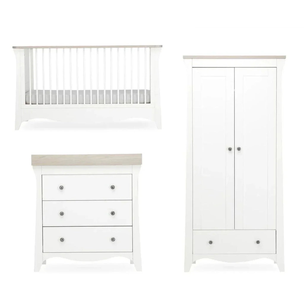 White nursery crib and matching dresser drawers with knobs.