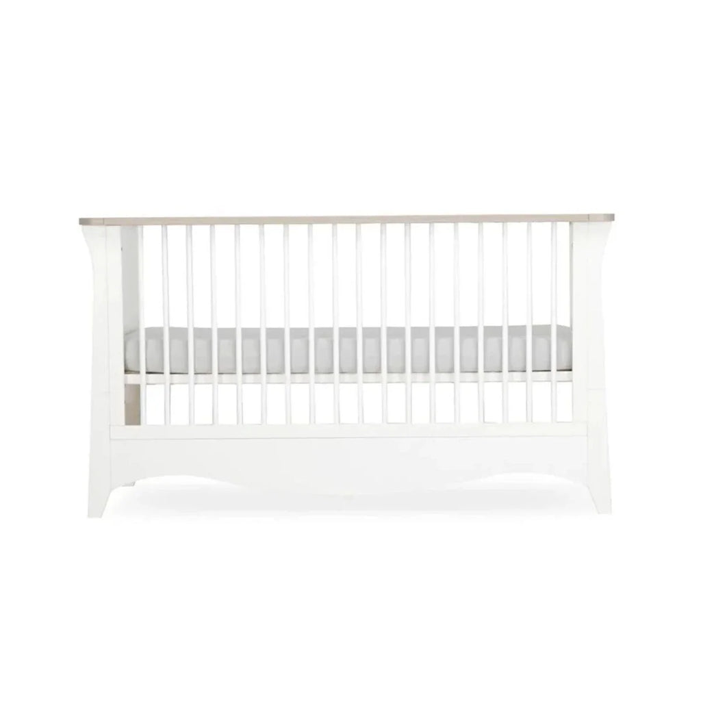 White nursery crib side panel with vertical slats and curved base