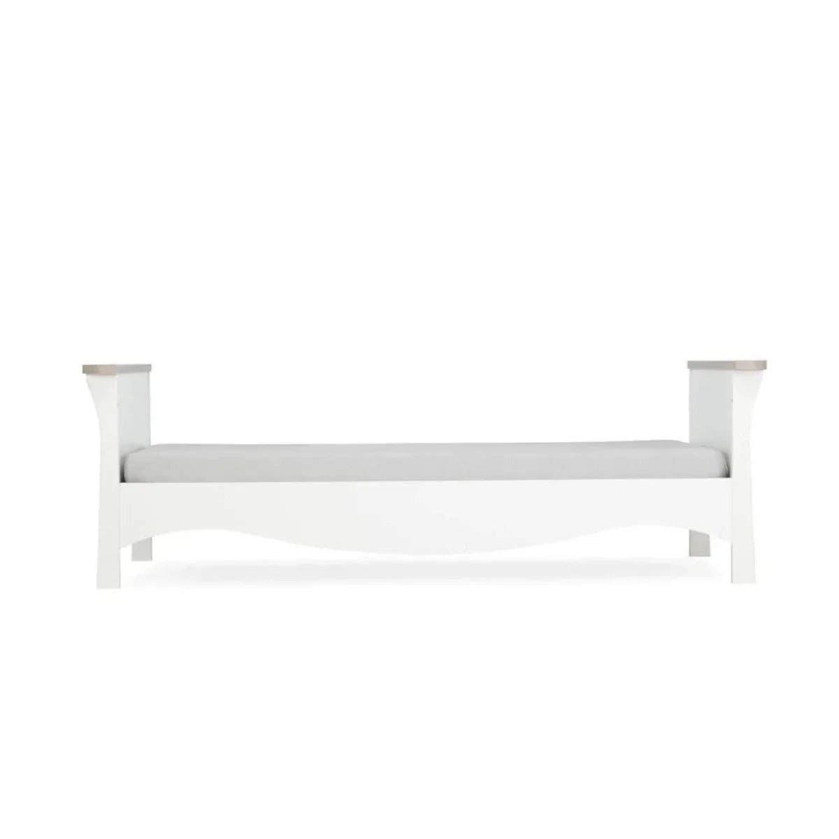 White nursery crib with horizontal top rail and mattress platform