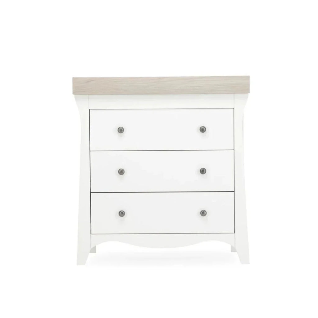 White nursery dresser with three drawers and ash-toned top trim