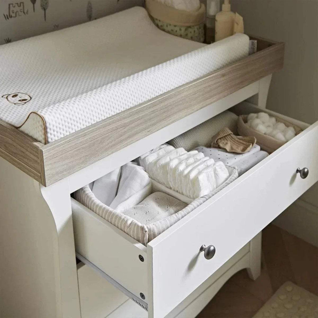 White dresser changer with open drawer showing changing compartment and mattress support
