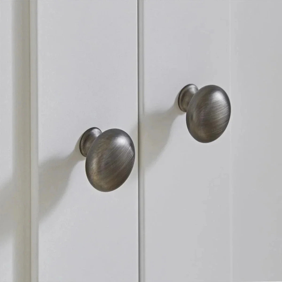 White wardrobe doors with brushed metal round knobs